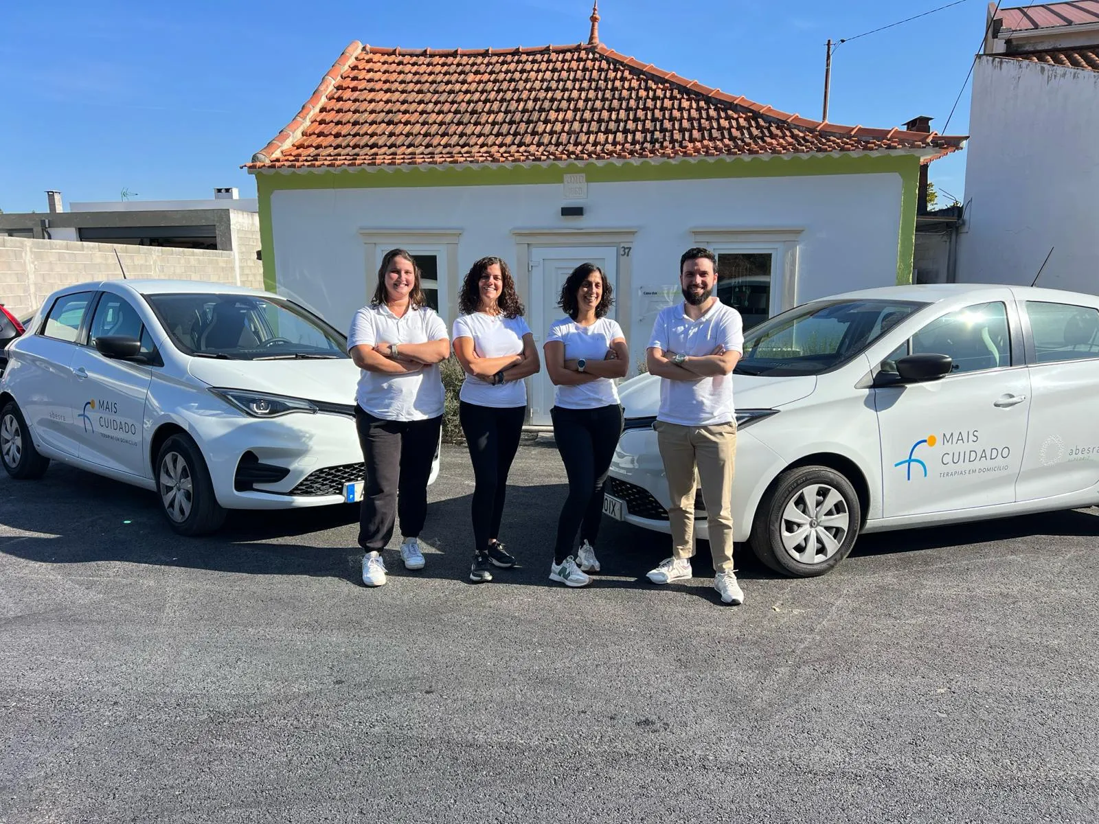 Equipa do Mais Cuidado — Terapias em Domicílio junto às duas viaturas do projeto, à porta da Casa das Janelas Verdes